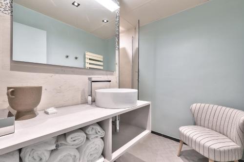 baño con lavabo y silla en Hotel 33 Marbeuf, en París