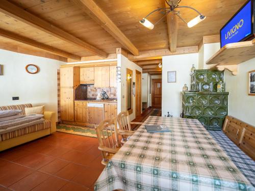ein Wohnzimmer mit einem Tisch und einer Küche in der Unterkunft Bait da Salient MyHoliday Livigno in Livigno