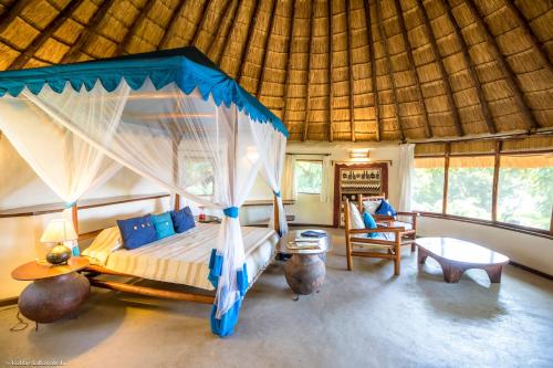 een slaapkamer met een hemelbed in een kamer bij Mfangano Island Lodge in Mbita