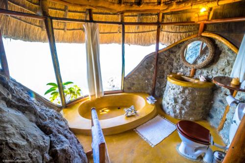 a bathroom with a tub in a tree house at Mfangano Island Lodge in Mbita