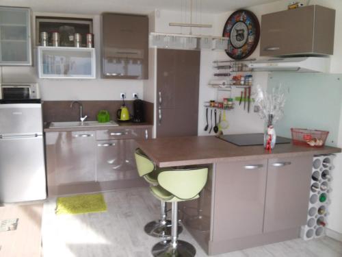 une cuisine avec un comptoir et une horloge au mur dans l'établissement APPART MER CALME ET ENSOLEILLEE, au Grau-du-Roi