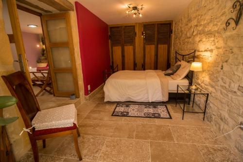 une chambre avec un lit et un mur en pierre dans l'établissement Gîte 2 La grange des hirondelles 3 lits doubles 6 adultes situé entre Bourgogne MORVAN et Vignoble Maison entière labellisée à Gîte de France sous 71 G 2005 labellisé 3 épis - Loft grand volume dans corps de ferme rénovée ANTULLY chez MAYMARD Yannick, à Antully