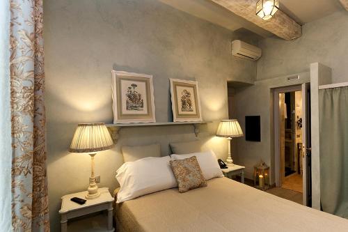 una camera da letto con un letto con due lampade sopra di Relais Del Maro a Borgomaro