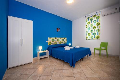 a blue bedroom with a bed and a chair at Casa Contrada Molinello in Castellammare del Golfo