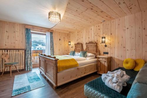 - une chambre avec un lit dans une pièce dotée de murs en bois dans l'établissement Hotel Jägerheim 3S, à Selva di Val Gardena