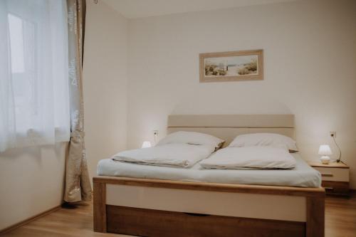 um quarto com uma cama com lençóis brancos em Peter Lamster Top1 em Frauenkirchen