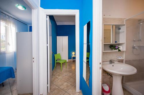 a bathroom with blue walls and a sink and a toilet at Casa Contrada Molinello in Castellammare del Golfo