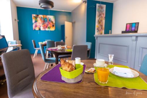a table with a plate of food and drinks on it at Élysée Hôtel in Châteauroux