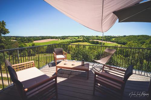 a deck with a table and chairs and an umbrella at La Fournial in Lunac