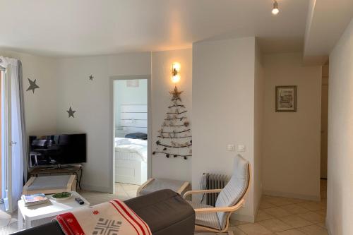 uma sala de estar com uma árvore de Natal na parede em Le Montbonnot Luminous T2 Garden - Terrace #P0 em Montbonnot-Saint-Martin