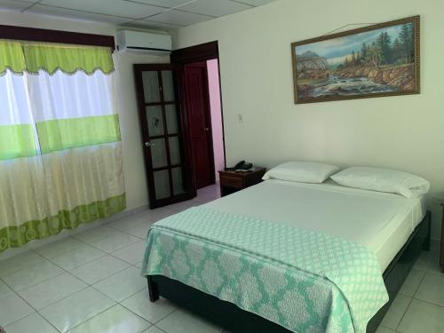 - une chambre avec un lit et une photo sur le mur dans l'établissement HOTEL CARISABEL, à Aguadulce