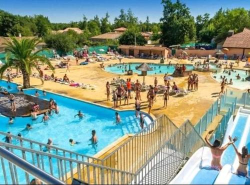 un groupe de personnes dans une piscine d'un complexe hôtelier dans l'établissement Mobil-home du Lac Mimizan, à Aureilhan