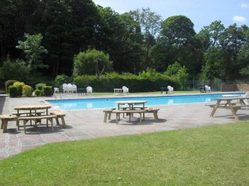 a group of picnic tables in front of a pool at SNOWDON LODGE - GLAN GWNA HOLIDAY PARK CAERNARFON - Luxury Family Lodge in Caernarfon
