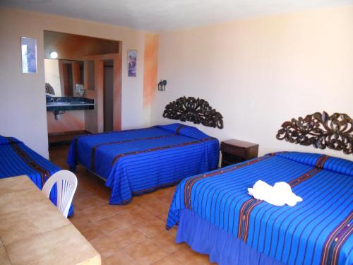 a hotel room with two beds with blue sheets at Perla Maya Hotel in Panajachel
