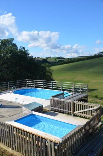 2 piscines sur une terrasse avec une clôture dans l'établissement chambres d'hôtes N7, à Riguepeu