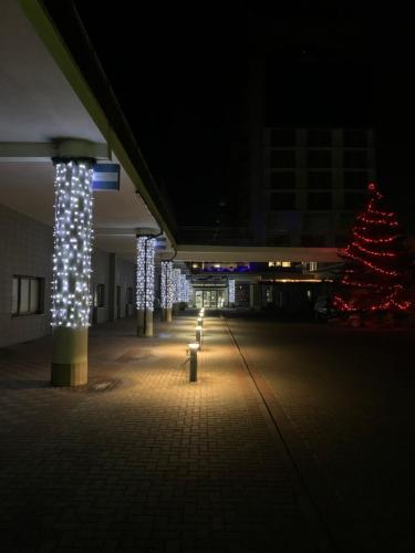 una fila de luces en un edificio con un árbol de Navidad en Apartamenty Arka Medical Spa **** en Kołobrzeg