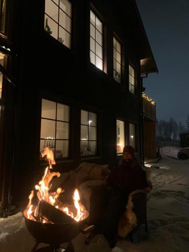 a person sitting in front of a fire pit at Vid Gondolen in Hemavan