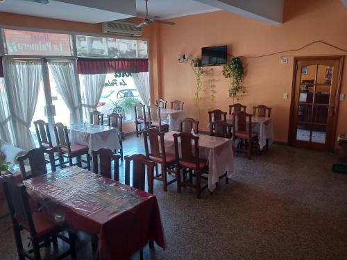 un restaurante con mesas y sillas en una habitación del Hotel La Palmera de Villa Gesell
