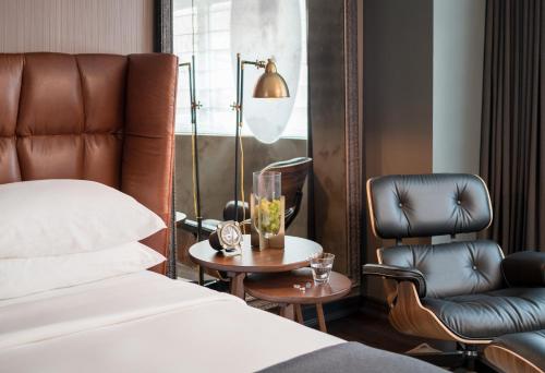 a bedroom with a bed and a chair and a table at Hotel AKA Boston Common in Boston