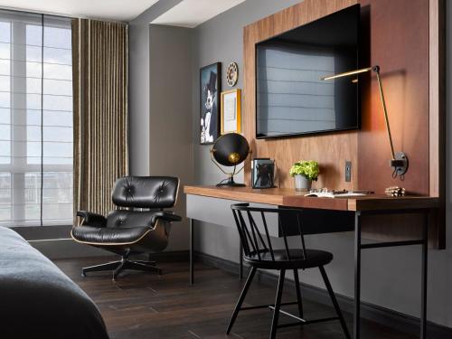a bedroom with a desk and a chair and a mirror at Hotel AKA Boston Common in Boston
