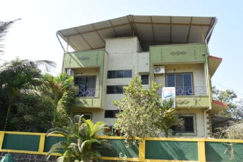 a building with a lot of trees in front of it at Gulmohar Cottages - Home Stay in Alibag in Alibaug