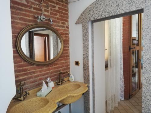 a bathroom with a stone sink and a mirror at La Palma appartamenti in Piombino