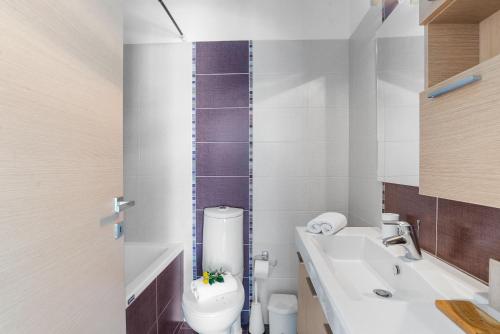 uma casa de banho branca com um WC e um lavatório em Almyrida Panorama II BY APOKORONAS-VILLAS em Almirída