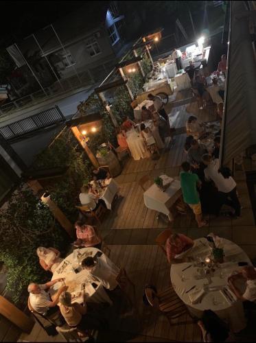 a group of people sitting at tables in a restaurant at Hotel Kunst in Krško