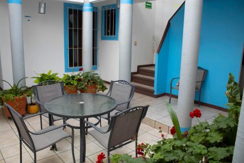 een patio met een tafel, stoelen en planten bij HOTEL NIUT-JA in Oaxaca City