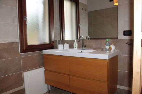 La salle de bains est pourvue d'un lavabo et d'un miroir. dans l'établissement Casa Ortensia, à Tortolì