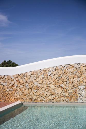 a stone wall next to a swimming pool at Monte do Giestal - Casas de Campo & Spa in Abela