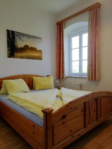 a wooden bed in a room with a window at Mayr-Eichberg, Familie Berndl in Wolfsbach