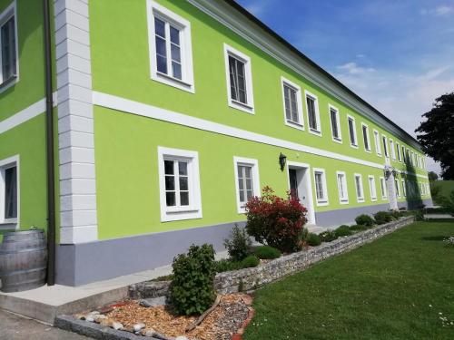 ein grün-weißes Gebäude mit einem Hof in der Unterkunft Mayr-Eichberg, Familie Berndl in Wolfsbach