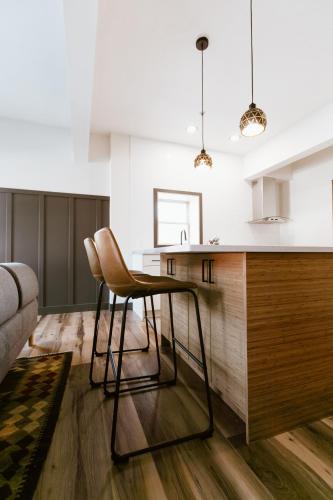 a kitchen with a counter and chairs in a room at The Flying Steamshovel Inn in Rossland
