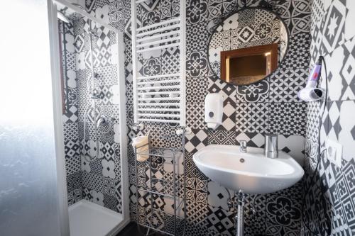 a bathroom with black and white tiled walls and a sink at CconfortHotels R&B Dolci Emozioni in Bari