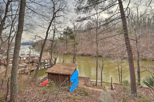 a small wooden shack next to a river with trees at Relaxing Retreat with Private Dock on Claytor Lake! in Dublin