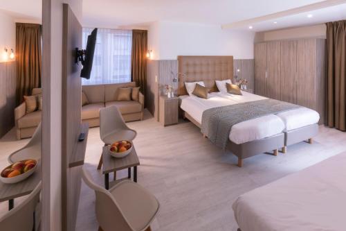 um quarto de hotel com uma cama e um sofá em Hotel Atlanta Knokke em Knokke-Heist