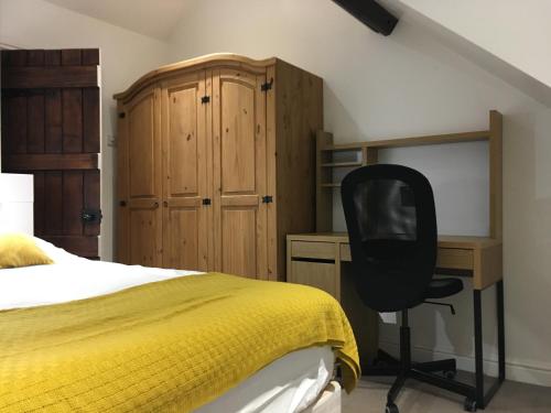 a bedroom with a bed and a desk and a chair at Countryside townhouse in Shireoaks