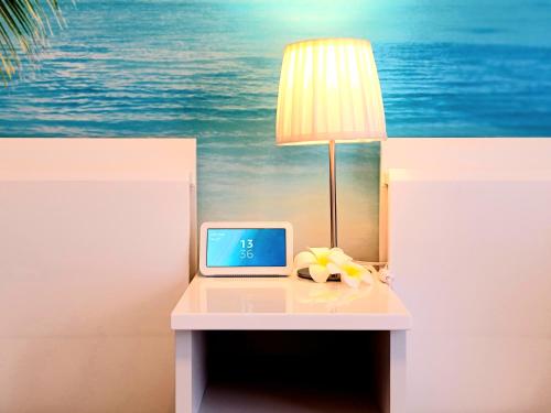 a table with a lamp and a laptop on it at "徹底清潔のゆったり64平米2LDK, 人気のリゾートタウン北谷で暮らすように過ごす, 高速ICまで車で3分, 沖縄アリーナまで徒歩圏内" Villa Blu Okinawa Chatan 3-2 ヴィラブルー沖縄北谷3-2 in Chatan