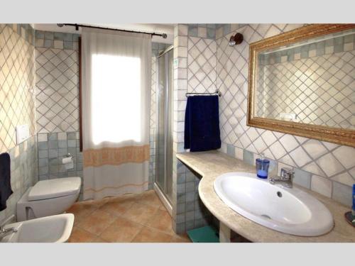 a bathroom with a sink and a toilet and a mirror at La Sima villa con piscina vista mare San Pantaleo Sardegna in San Pantaleo