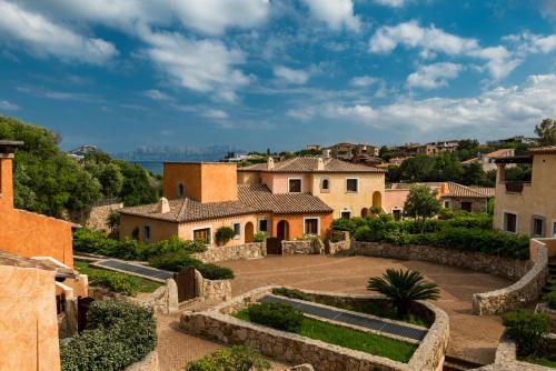 ゴルフォ・アランチにあるVillaggio Perlaceaの庭園と建物のあるヴィラの景色を望めます。