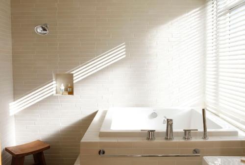 a white bathroom with a tub and a sink at H2hotel in Healdsburg