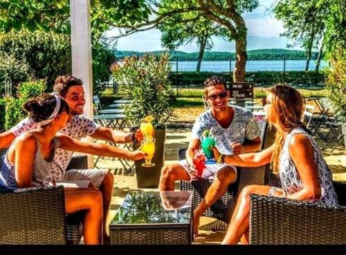 un groupe de personnes assises autour d'une table dans l'établissement Mobil-home du Lac Mimizan, à Aureilhan