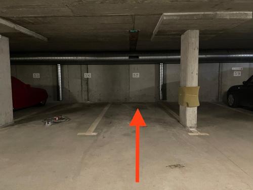 an empty parking garage with an orange arrow in it at Magnifique appartement aux Diablerets avec vue imprenable in Les Diablerets