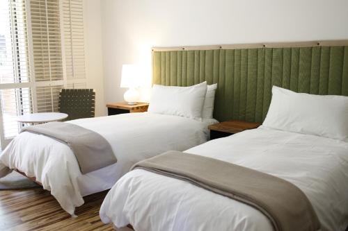 duas camas num quarto de hotel com lençóis brancos em H2hotel em Healdsburg