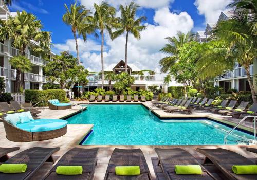 a pool at the resort with lounge chairs and palm trees at Opal Key Resort & Marina in Key West