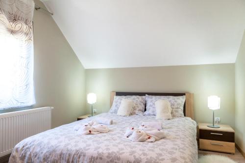 Un dormitorio con una cama con tres animales de peluche. en Vila Maja, en Brestovac
