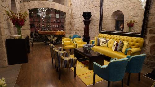 a living room with a yellow couch and chairs at Hotel De La Soledad in Morelia