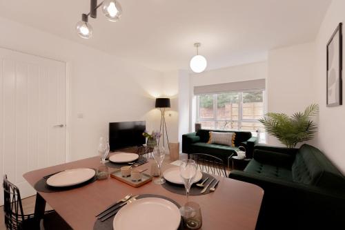 een woonkamer met een tafel en een eetkamer bij Moseley Gardens Fallowfield in Manchester