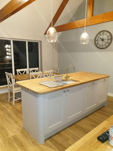 a kitchen with a counter with a sink and a clock at Congesquoy Barn in Stromness
